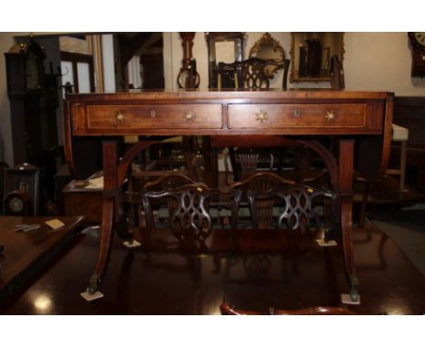 A Regency rosewood and mahogany banded sofa table, fitted two drawers with brass star handles, on splay castored supports, 52