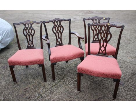 A set of four mahogany Chippendale design carved splat back dining chairs, upholstered in a pink brocade, on chamfered suppor