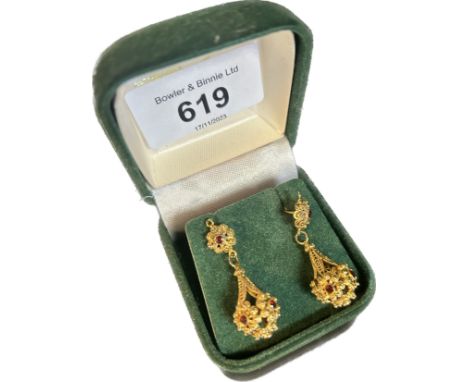 A pair of 9ct yellow gold Indian style, ruby set drop earrings of pendent form, pierced and cast decoration, post fittings[Le