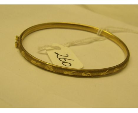 An engraved 9ct hinged slender bangle    