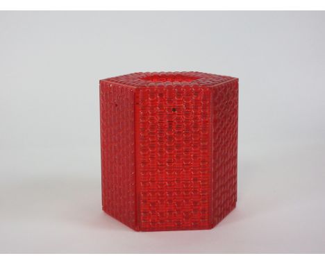A red perspex lamp shade of hexagonal form