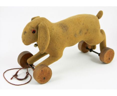 Early Steiff felt rabbit on wheels, circa 1909, the brown straw filled rabbit with black boot button eyes, lined in red felt,