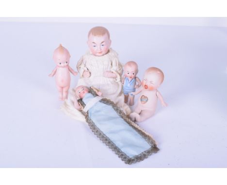 Rose O’Neil all-bisque Kewpie, with side glancing eyes, water melon smile and tiny blue wings, signed to foot, 4 ½” (11 1/4cm