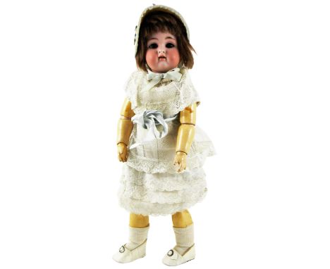 K&R bisque head doll, German circa 1910, with weighted brown glass eyes, open mouth, upper teeth and brown wig, on a fully jo