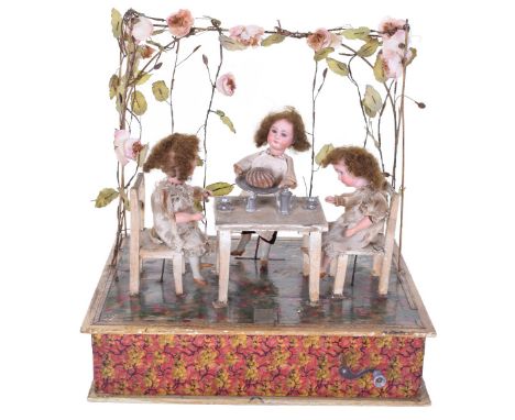 A hand wound musical automata Tea Party, German circa 1910, with three bisque head dolls with glass eyes and closed mouths, t