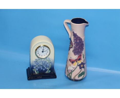 AN OLD TUPTON WARE MANTEL CLOCK TOGETHER WITH A TALL JUG