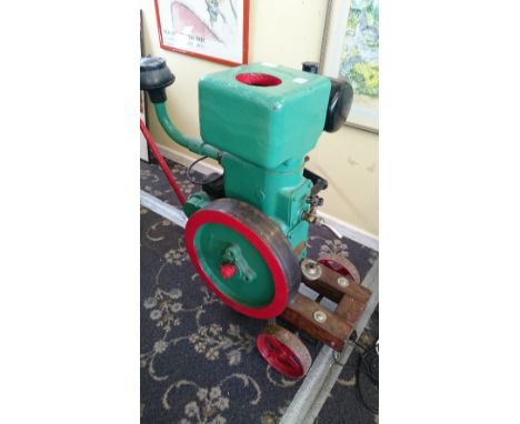 An early 20th century Ruston & Hornsby static petrol driven steam engine on fixed wooden trolley.