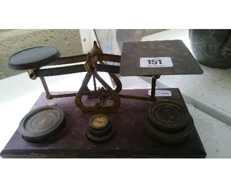 A small set of brass postage scales and weights.