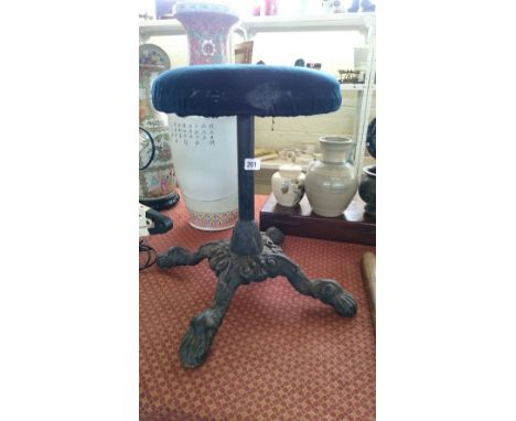 A cast iron based stool resting on four claw supports.