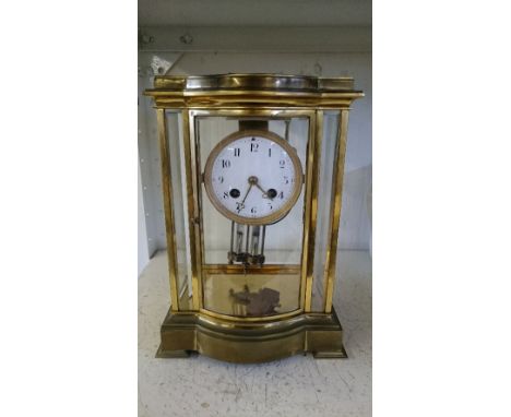 A 19th century brass and glass cased French mantle clock with enamel dial and visible mercury pendulum.