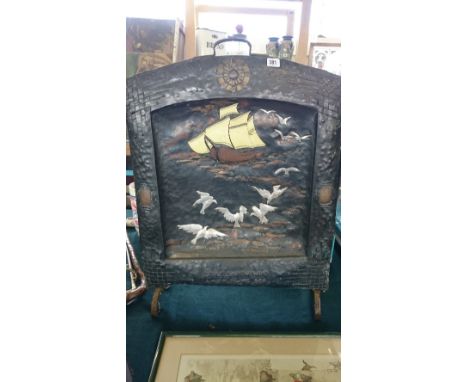 An Arts & Crafts copper fire screen decorated with a Galleon and Birds in flight on stylised sea with embossed inscription "S