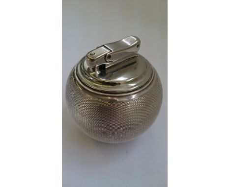 An engine turned silver cigarette lighter: The Witch Ball by Comyns, London.