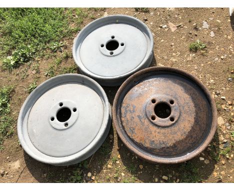 Three Ferguson tractor front wheels.