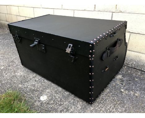 A large leather bound travel trunk with sloping back as fitted to the rear of a vintage car. 