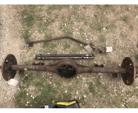 A Morris rear axle casing, a vintage car windscreen and two halfshafts; also a Morris curved front axle beam.