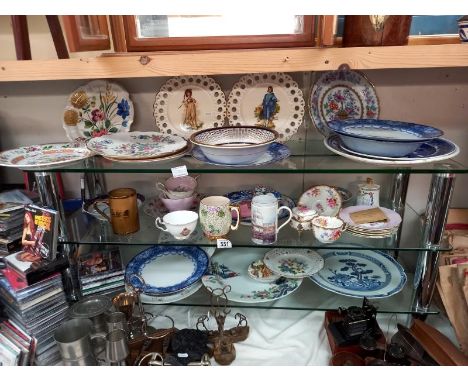 Three shelves of ceramics including Chinese plates.
