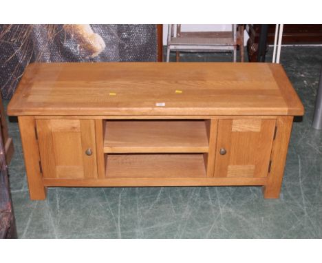 A light oak tv stand, fitted open shelf, flanked by cupboards, 50 cm high x 120 cm wide x 44 cm deep