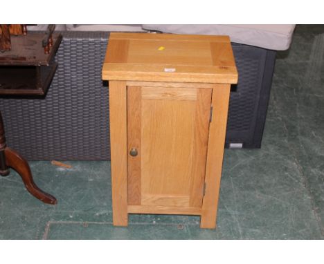 A modern light oak bedside cupboard 