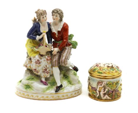 A German porcelain figure group,late 19th century, modelled as a lady and gentleman in traditional costume perched on a rock,