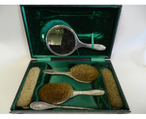 A silver mounted cased dressing table set, hallmarked Birmingham, comprising a mirror, four brushes and a button hook
