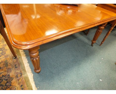 A Victorian mahogany extending dining table with extra leaf on ball and reeded tapering legs and ceramic castors 105cm wide, 