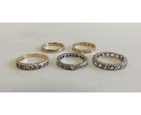 Three 9ct gold eternity rings together with a 9ct gold seven stone ring and a 9ct gold plain band