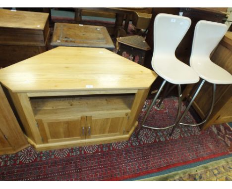 A light oak television cabinet of canted form with recess and two cupboard doors below 107cm wide, 50cm deep, 64cm high and t