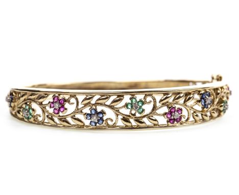 COLOURED GEM AND DIAMOND BANGLE the openwork bezel 11mm wide, set with red, green and blue gem set flower motifs, each with a