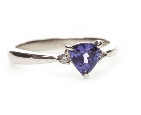 PURPLE GEM SET AND DIAMOND THREE STONE RING, the trillion shaped purple gem flanked by two round brilliant cut diamonds of ap