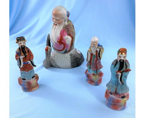 A Chinese ceramic group depicting bearded man with a large pomegranate riding a large bird impressed seal mark to base height