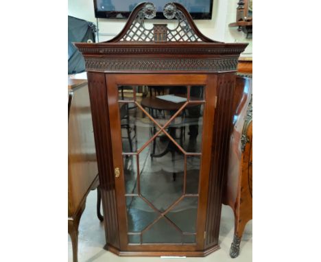 A 19th century mahogany Chippendale style corner cabinet with pierced and blind fret decoration, enclosed by glazed door 