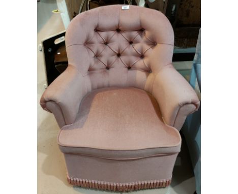 A pink dralon button back armchair; a floral upholstered ottoman