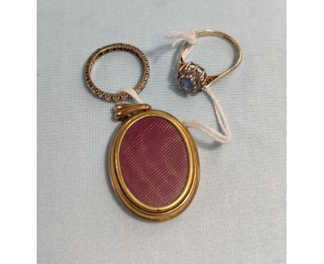 A 9 carat gold dress ring, a 9 carat gold eternity ring set with colourless stones and a gilt cased picture fob / locket 