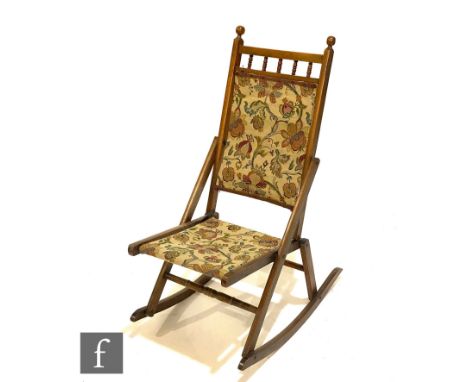 A late Victorian walnut spindle back steamer rocking chair with tapestry fabric seat and back.