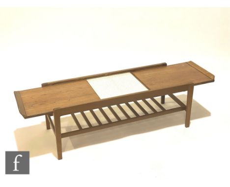 A 1960s teak coffee table of rectangular form, the top with metamorphic action opening to reveal a central leaf patterned lam