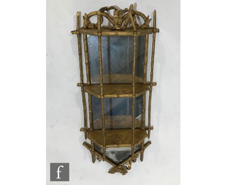 A late 19th Century three tiered mirrored back wall bracket, the arch pediment mounted with a bow over simulated bamboo sides