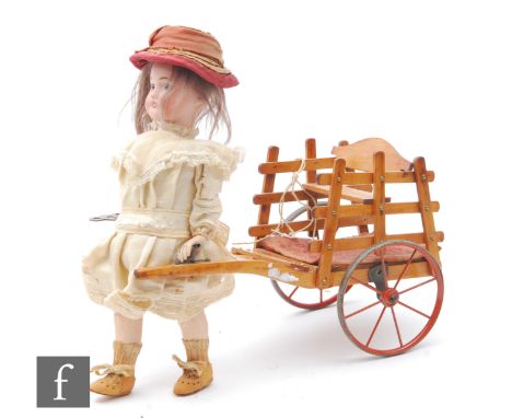 A late 19th Century French Roullet et Decamps girl pulling a cart automaton, circa 1890, the Limoges bisque socket head with 