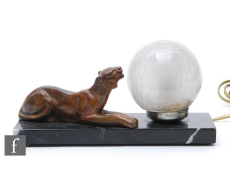 A 20th Century French Art Deco spelter table lamp, decorated with a recumbent tiger, with a crackle glass sphere shade, all m