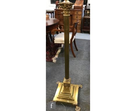 An early 20th Century brass adjustable Corinthian column standard lamp on stepped base and brass paw feet, height 186cm. 
