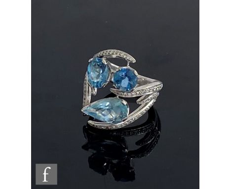 A contemporary 18ct hallmarked white gold aquamarine and diamond interlocking Aurora ring set with three aquamarines to diamo