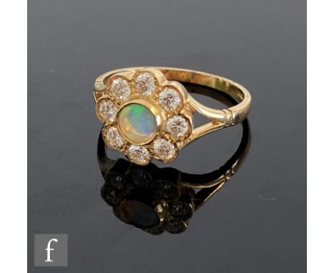 A 9ct hallmarked opal and diamond daisy cluster ring, central opal within a border of eight brilliant cut diamonds, all to sp