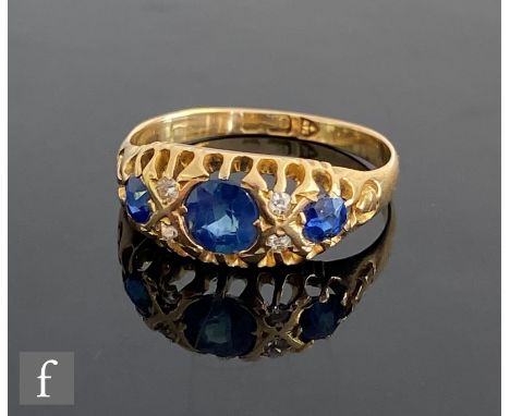 An early 20th Century 18ct seven stone sapphire and diamond boat shaped ring, three sapphires spaced by pairs of diamonds, we