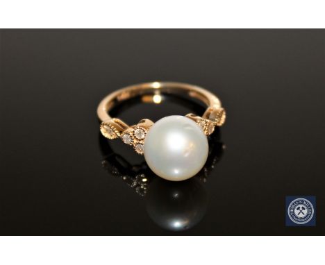 A 14ct yellow gold pearl and diamond ring, the white, cultured South Sea pearl flanked by eight brilliant-cut diamonds, the t