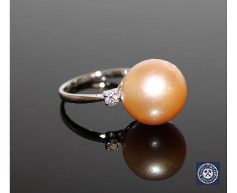 A 14ct yellow gold pearl and diamond ring, the gold/yellow cultured South Sea pearl flanked by two brilliant-cut diamonds, th