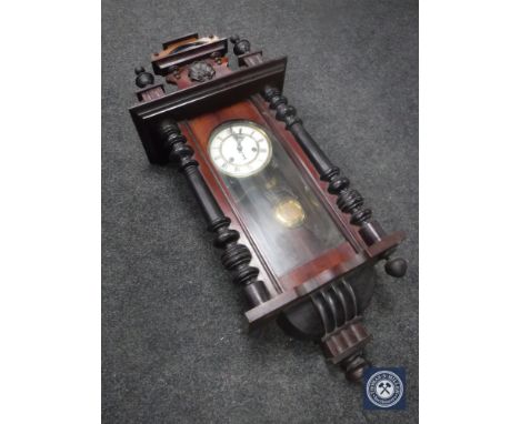 A Victorian mahogany wall clock with enamel dial, pendulum and key 