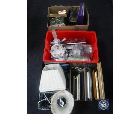 Four boxes containing tins, table lamp shades, china, glass etc