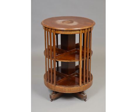 An Edwardian inlaid mahogany circular revolving bookcase of three tiers, with pierced galleries, on platform base with four c