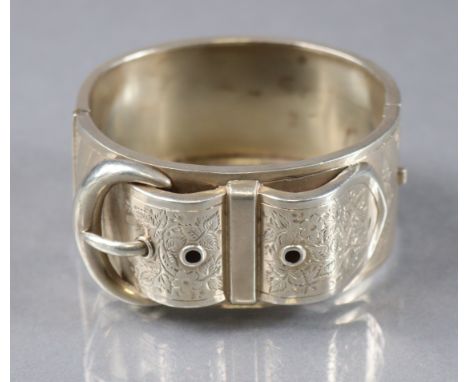 A Victorian silver wide stiff-hinged bangle with engraved belt buckles motif, Birmingham 1885, by Jackson Bros. (1.6oz).