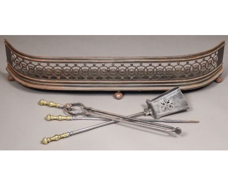 Three Georgian steel fire implements with brass handles, each approx. 69cm; a ditto fender with pierced neoclassical decorati