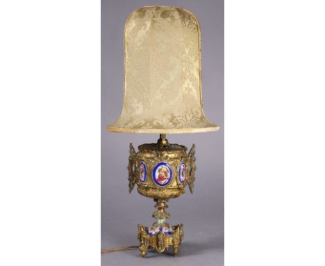 A late 19th century gilt-brass table lamp inset numerous painted porcelain panels, with associated shade, cm. high.